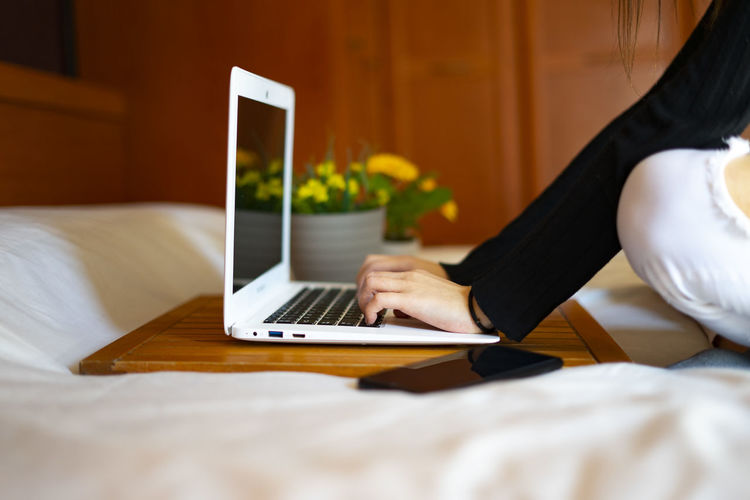 Woman working in bed with the computer.