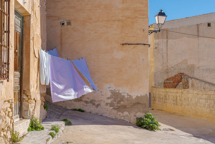 Clothes drying on wall by street against building