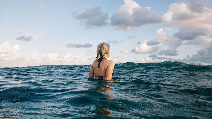 Rear view of woman swimming in ocean
