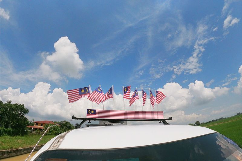 Flag on boat against blue sky