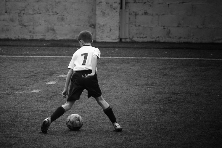 Rear view of boy playing soccer 