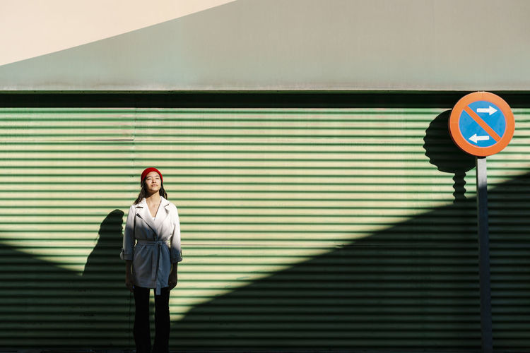Young woman in front of green corrugated wall