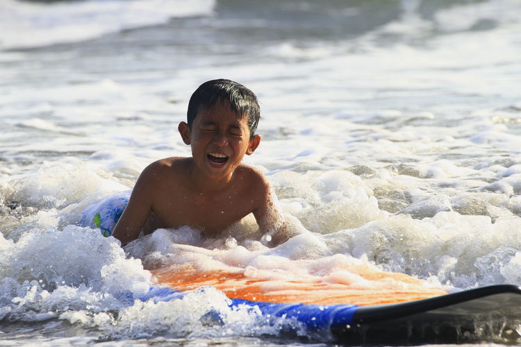 Portrait of shirtless boy in sea