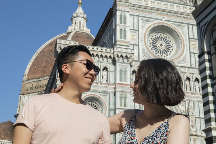 Mixed ethnicity couple smiling in front of the duomo in florence italy