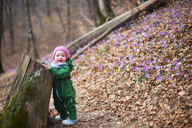 Cute toddler baby in spring forest full of wild irises. spring blossom in the forest. harmony, hope
