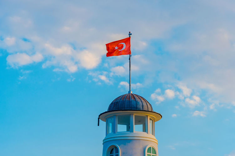 Low angle view of turkish flag on lighthouse against sky
