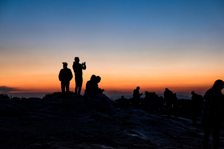 Silhouette of people at beach during sunset