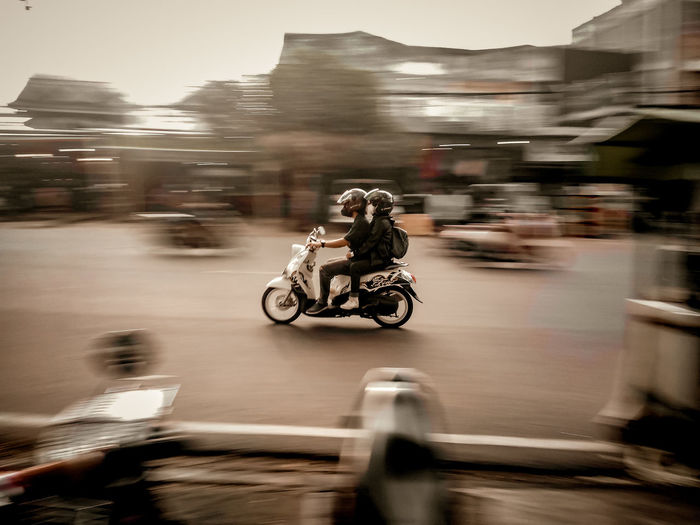 Blurred motion of person riding motorcycle on street