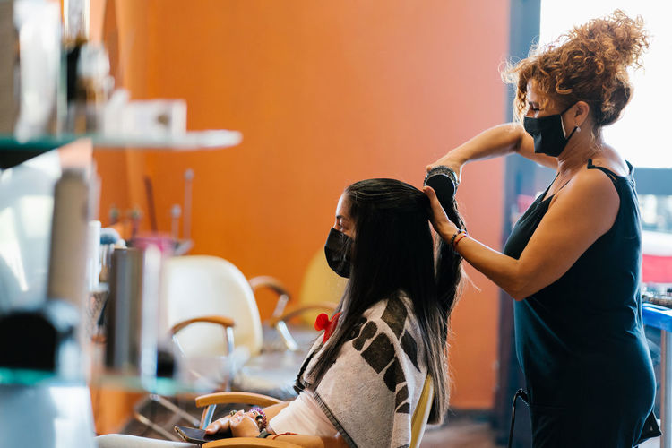 Woman in the hairdresser's with mask, cutting her hair, beauty salon