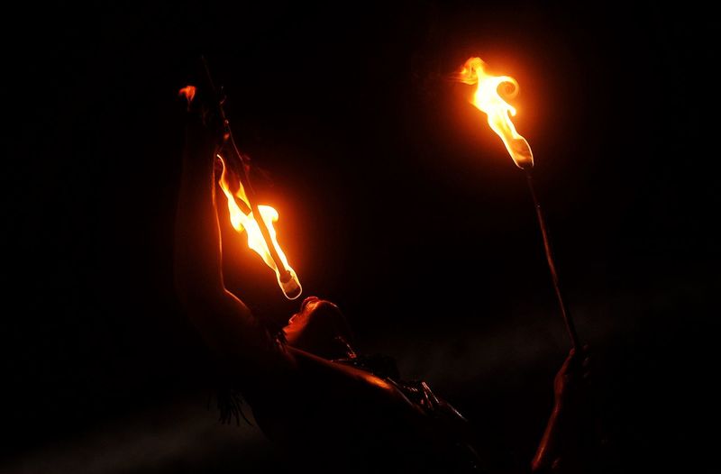 Cropped image of woman with fire at night