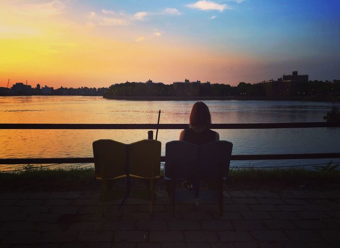 People looking at city at sunset