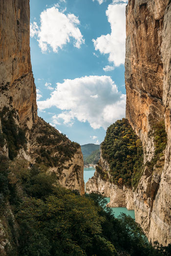 Blue sky with clouds between narrow rocky cliffs. river in congost de mont rebei gorge in spain.