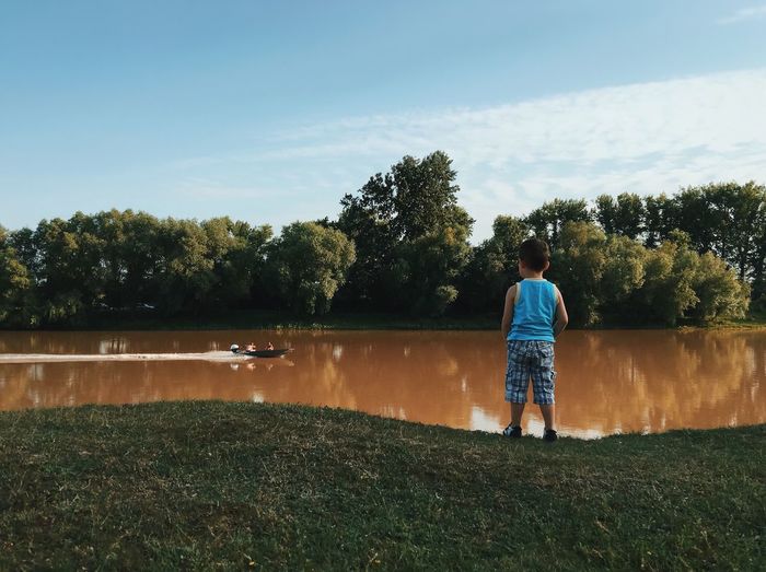 Full length of boy looking at river