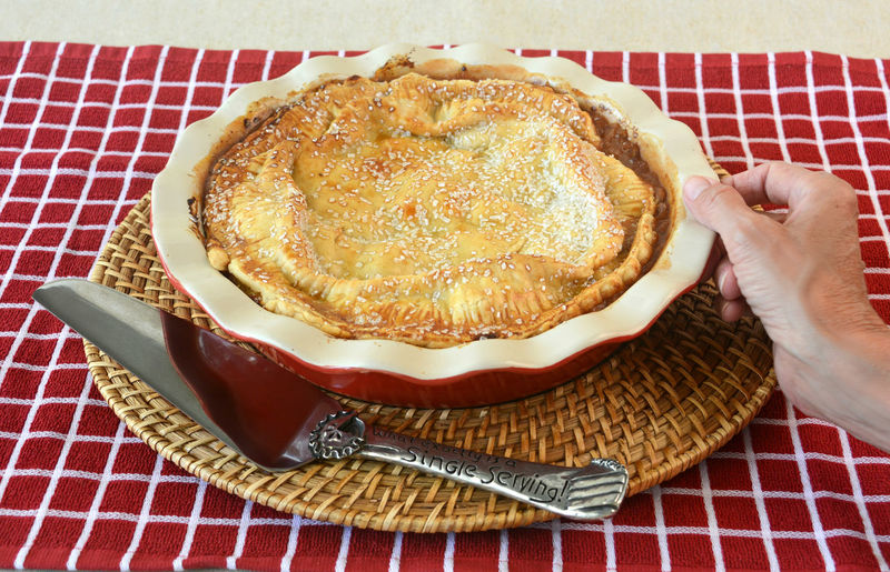 Cropped image of person holding apple pie bowl