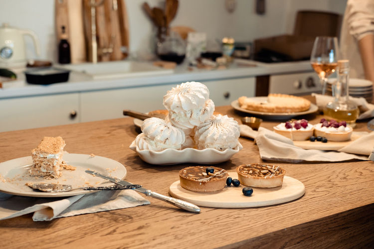 White airy meringue cake and round brown cake with nuts and caramel on the festive table