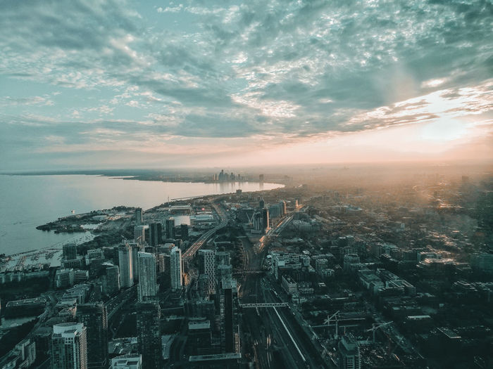 High angle view of cityscape and sea against sky during sunset