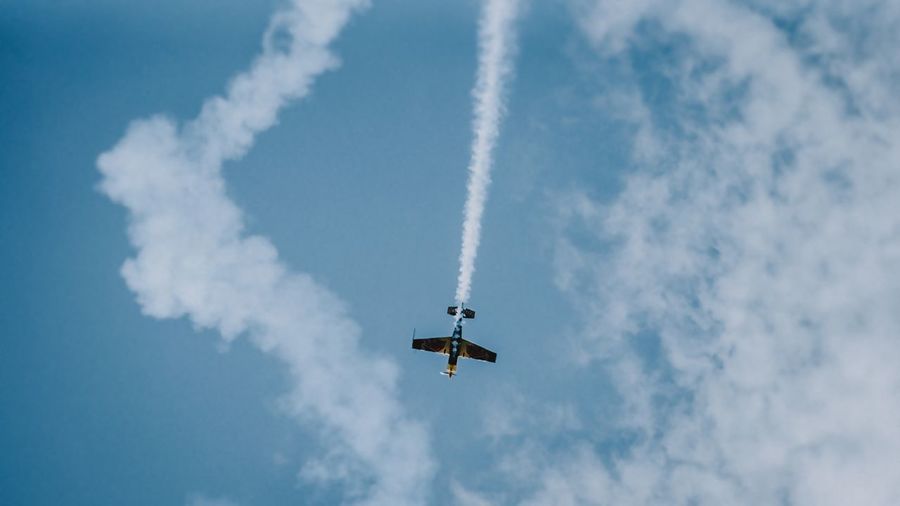 Low angle view of airplane against cloudy sky