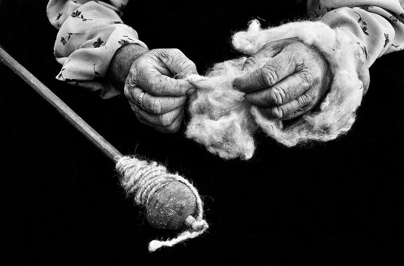 Close-up of hand holding rope over black background