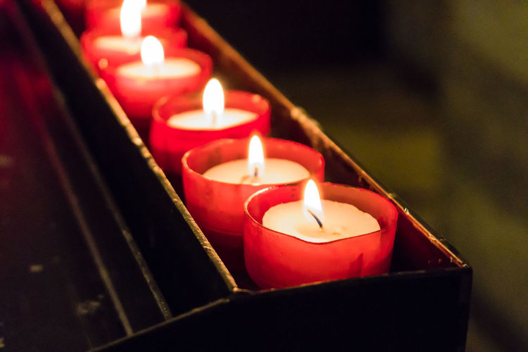 Close-up of candles on votive stand in church
