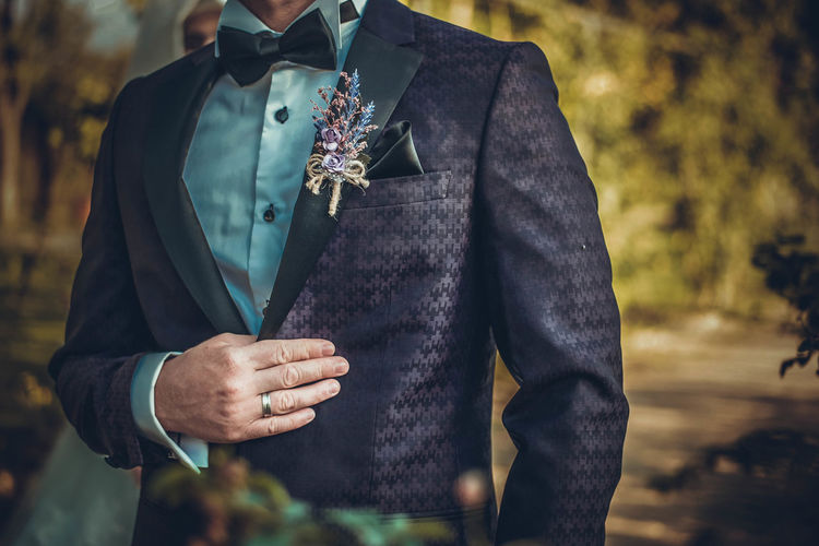 Midsection of bridegroom wearing suit during wedding