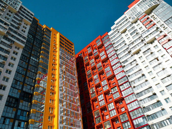 Low angle view of modern buildings against blue sky