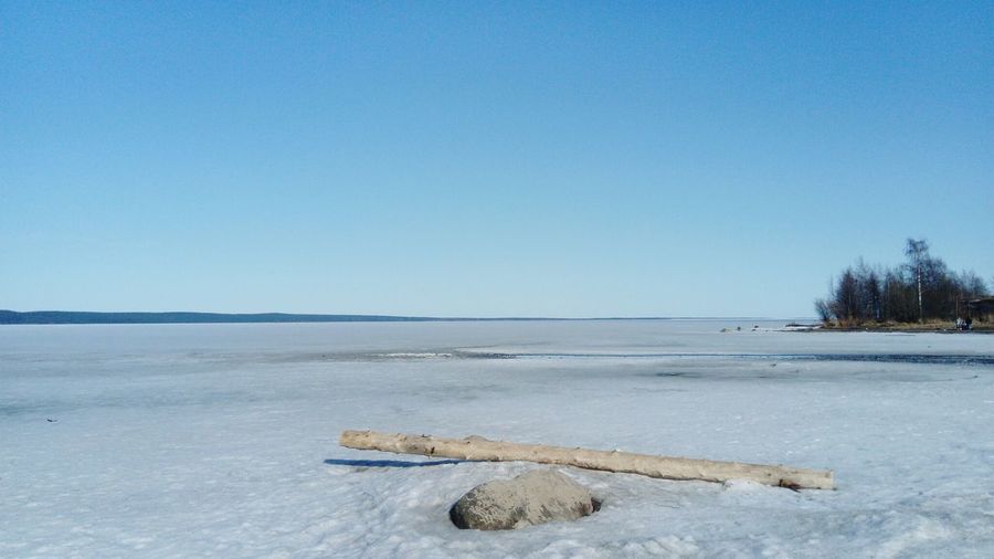Scenic view of frozen sea against clear blue sky during winter