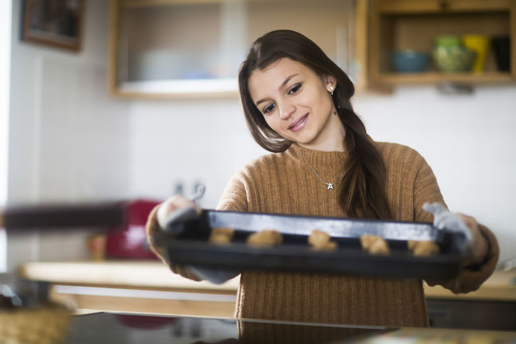 Young woman baking cookies in the kitchen
