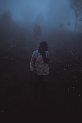 Woman standing on field during foggy weather