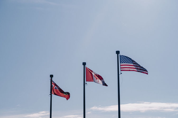 Three flags blowing in the wind.