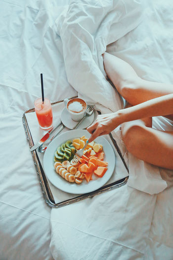 Bed Bedroom Breakfast Day Drink Food Food And Drink Freshness Fruit Healthy Eating Healthy Lifestyle High Angle View Human Body Part Human Hand Indoors One Person People Plate Ready-to-eat Real People Sheet Sweet Food Table Fresh On Market 2017