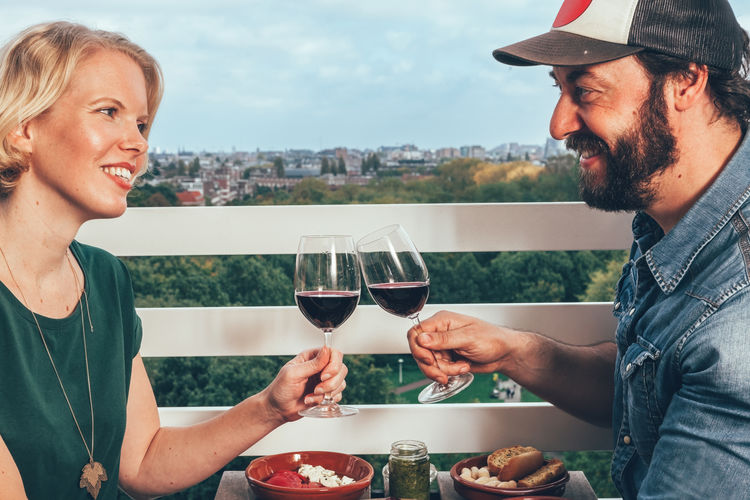 Diner for two at private terrace above amsterdam - wine cheering friends couple celebrating