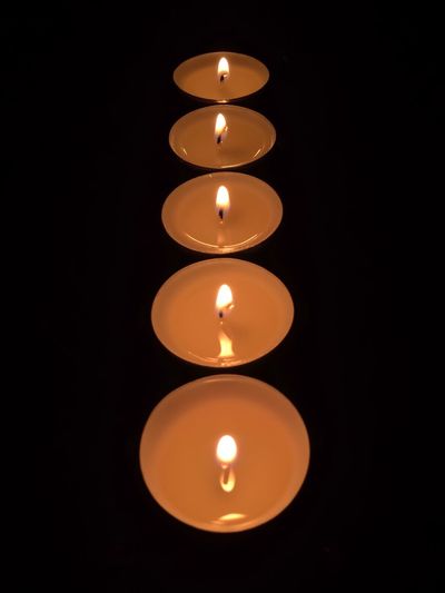 Lit candle in dark room