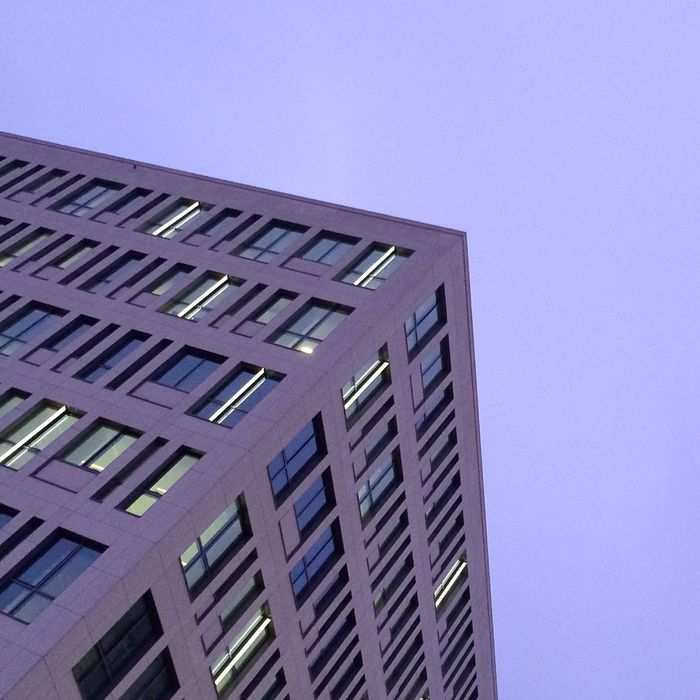 Purple tilt image of office building against sky at dusk