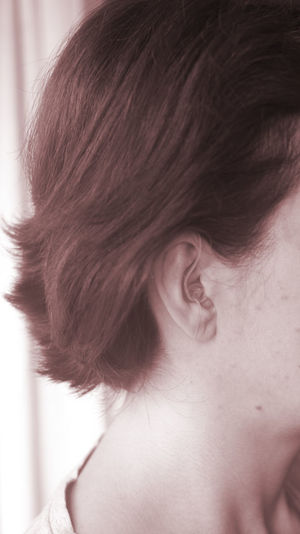 Close-up of woman with hearing aid indoors