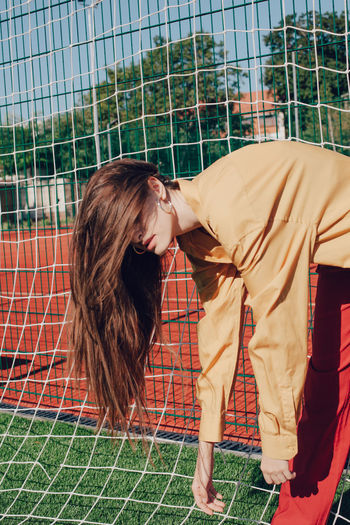 Young woman standing by soccer goal