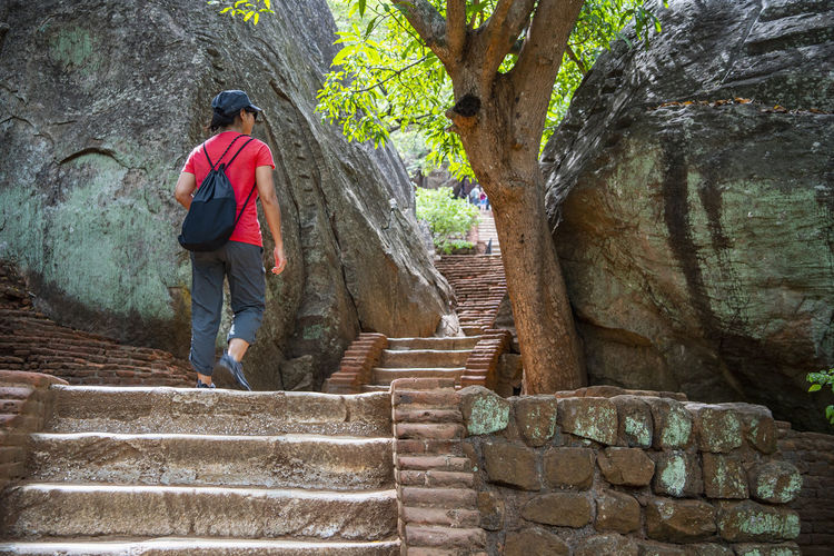 Woman climbing up the stairs towards the rock fortress of sigiriya