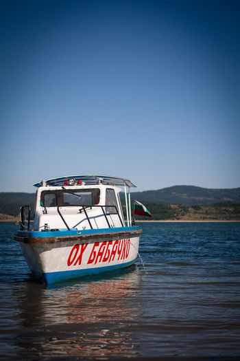 Scenic view of a boat in a  sea against clear blue sky