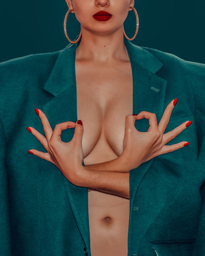 Midsection of seductive woman gesturing ok sign