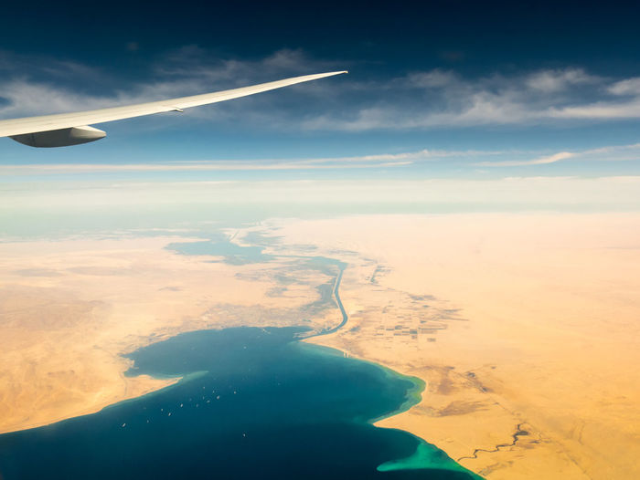 Airplane flying over landscape against sky