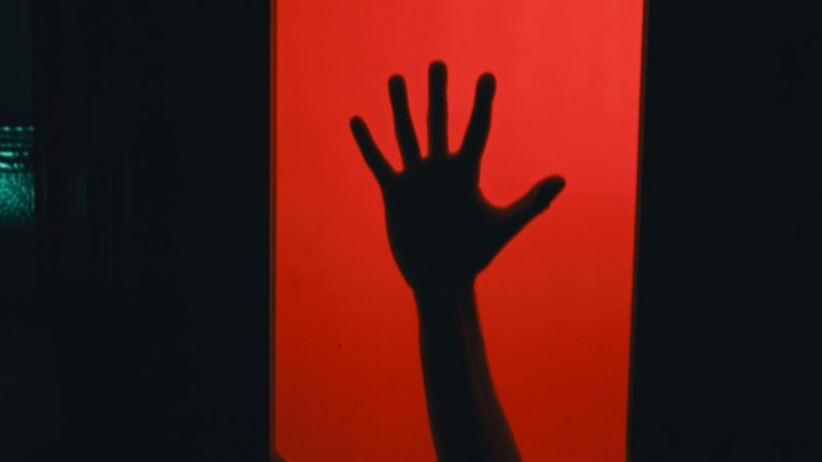 shadow of man gesturing against black background