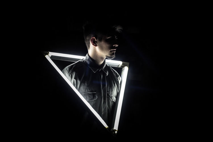FULL LENGTH OF BOY AGAINST ILLUMINATED BACKGROUND