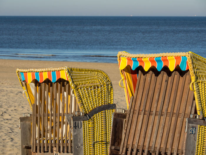 Multi colored chairs on beach against sky