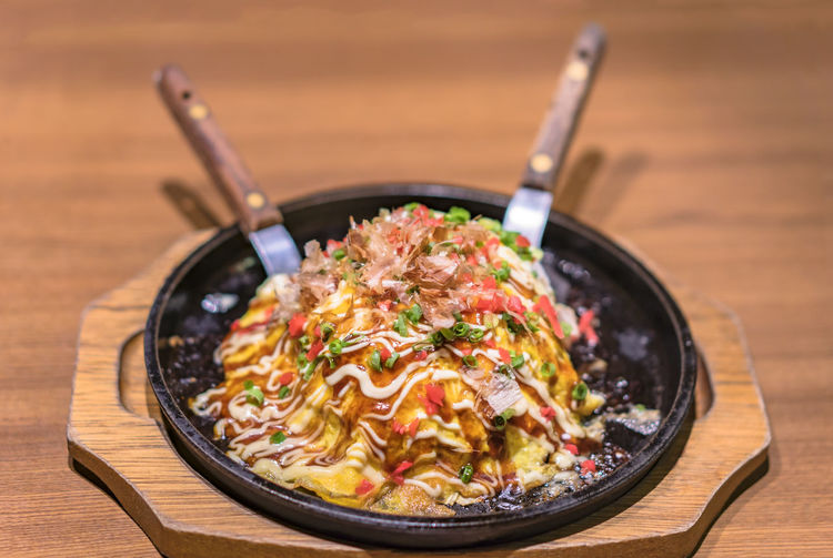 Japanese okonomiyaki covered with katsuobushi leek mayonnaise and bulldog sauce 
