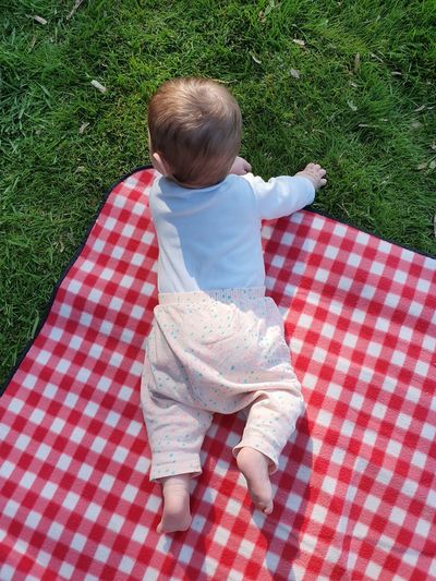 High angle view of cute baby girl on field