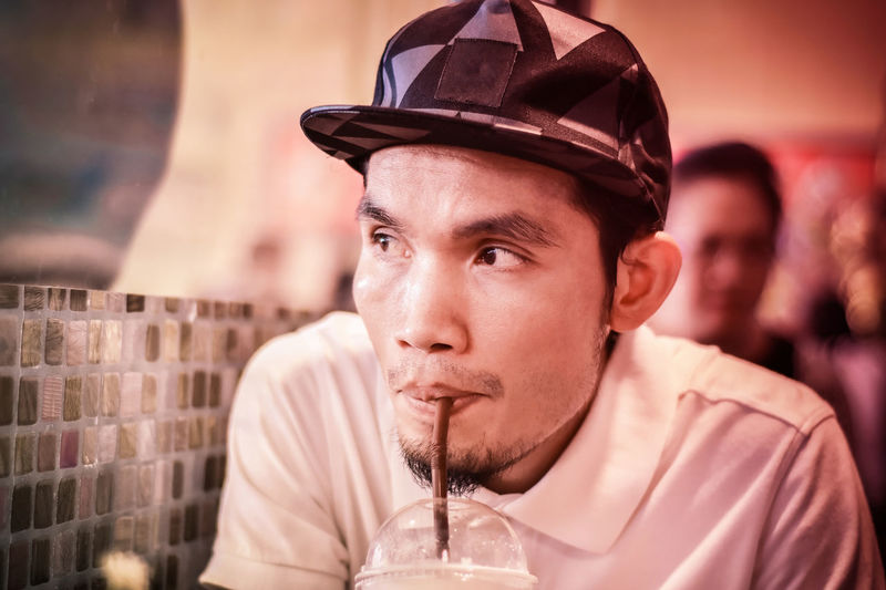 Close-up of man drinking juice at restaurant