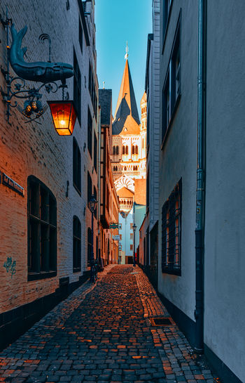 Narrow street amidst buildings at night