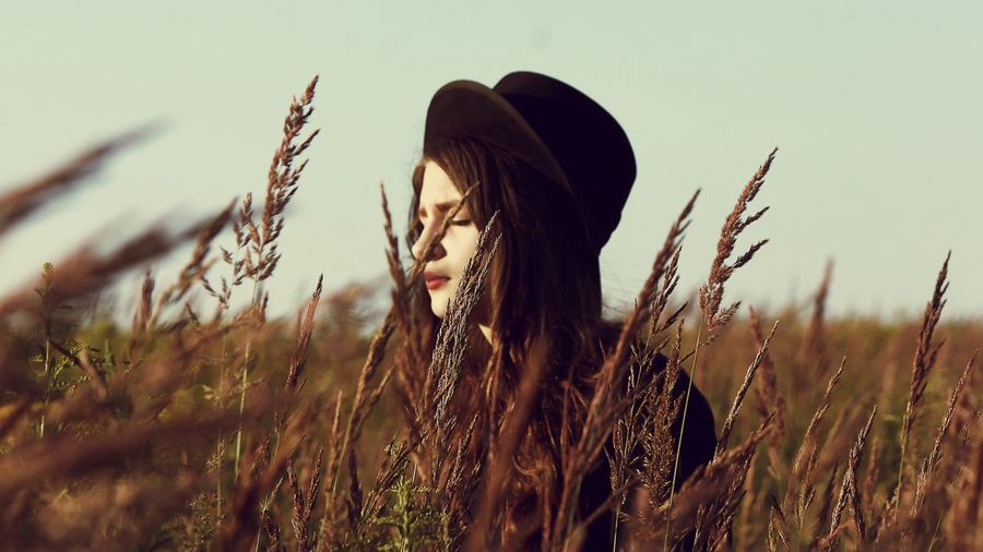Young woman with plants on field