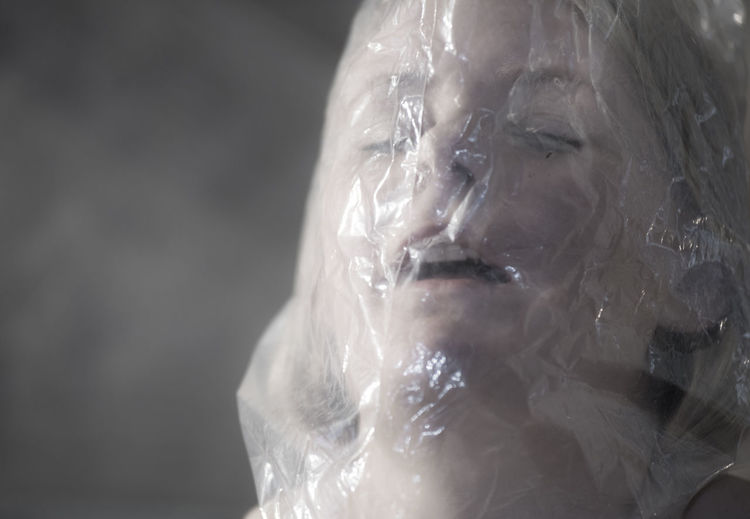 Close-up of woman with plastic bag on face