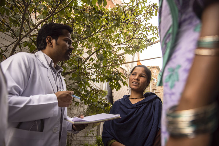 Male doctor talking to a young woman in slum
