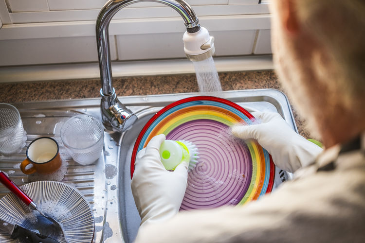 High angle view senior man washing dish at kitchen
